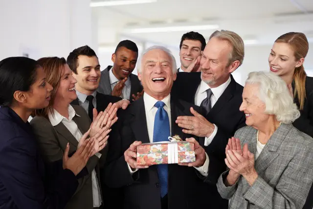 Des salariées réunies pour célébrer le départ en retraite de leur collègue, certain le félicite d'autres lui donne des cadeaux. 