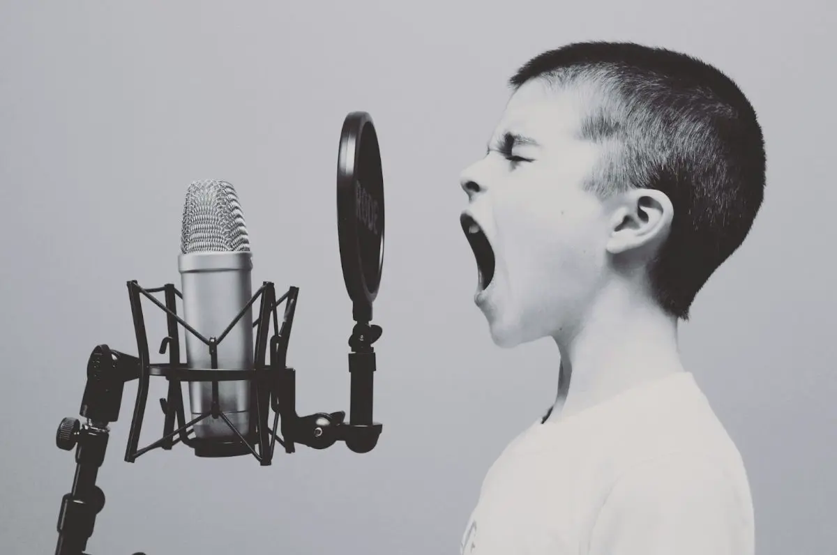 jeune garçon chantant avec passion devant son micro