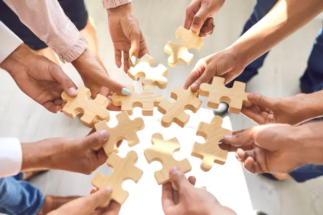 équipe rassemblée lors d'un team building  avec des piecs de puzzle