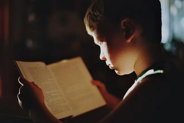 jeune homme lisant un cahier de notes