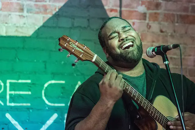 chanteur sur scène jouant de la guitare