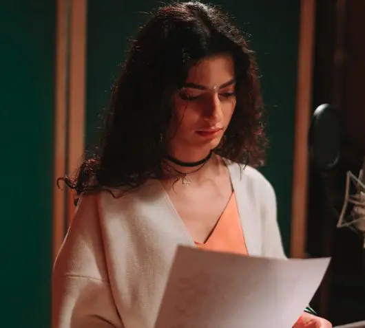 chanteuse en studio en train de lire ses notes